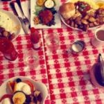 Various items on a red checkered tablecloth from a birthday brunch at Tooloulou's